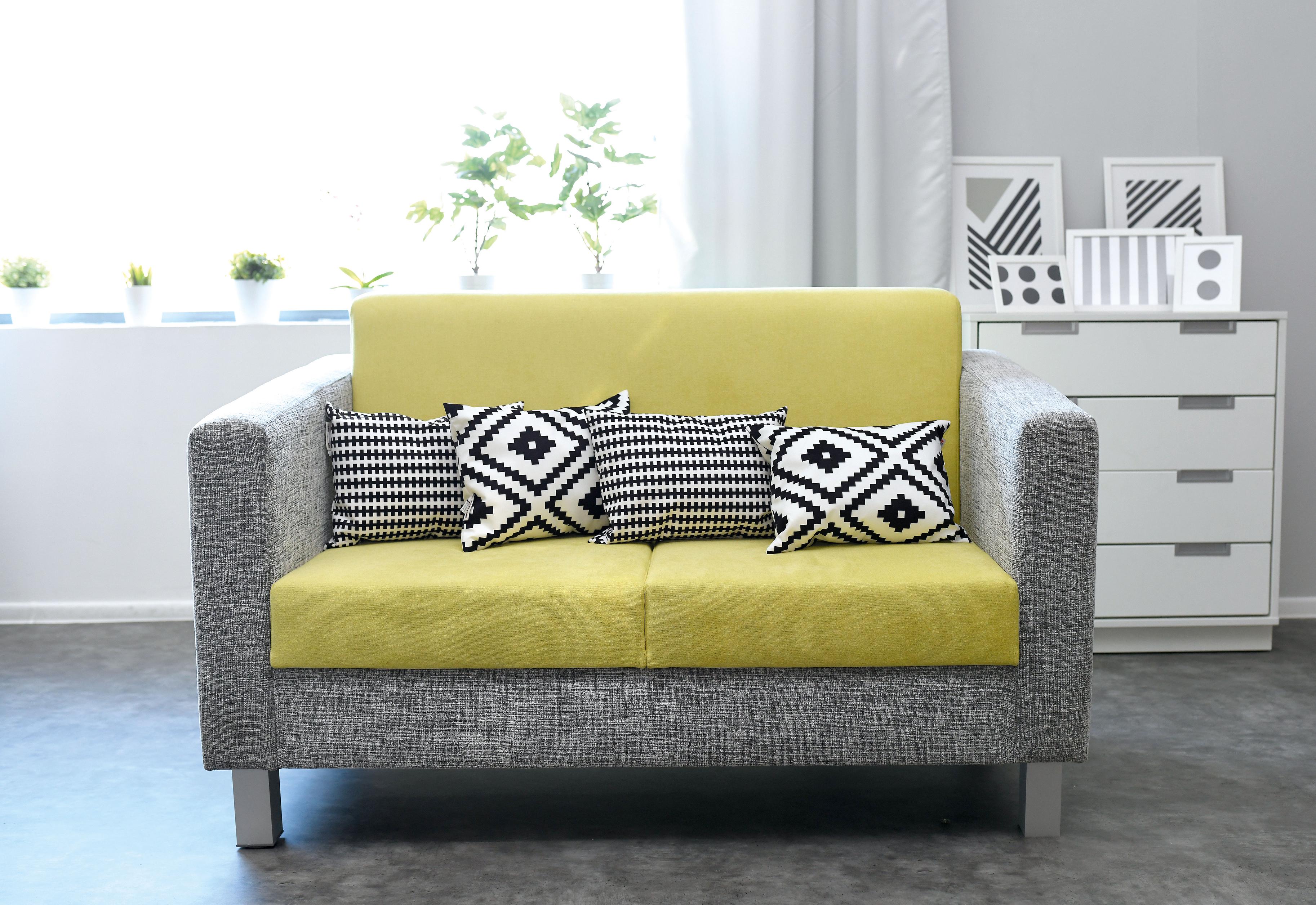 Kissen auf Sofa im modernen Gruppenraum arrangiert.