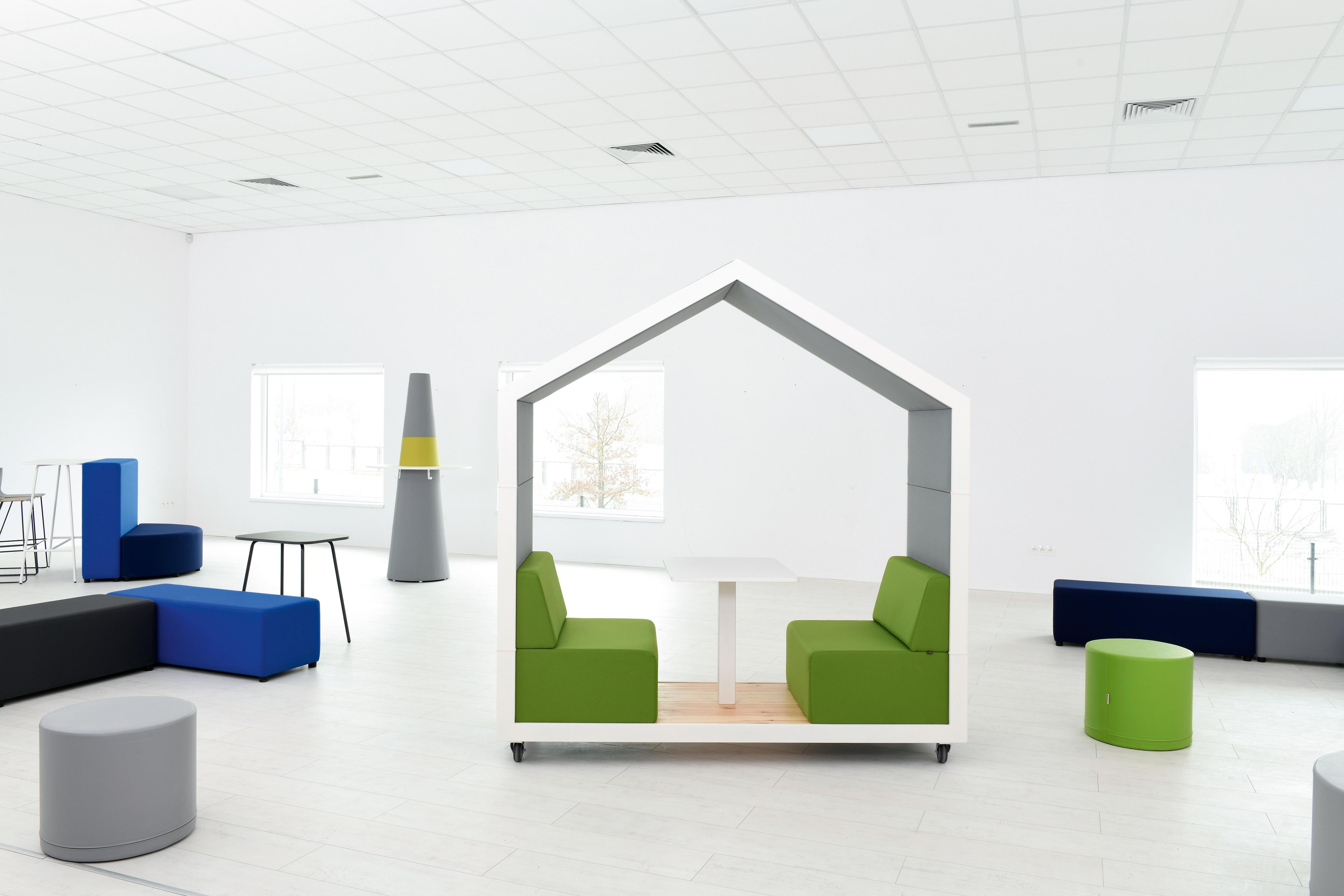 Meeting box im Raum mit verschiedenen farbigen Sitzmöbeln.