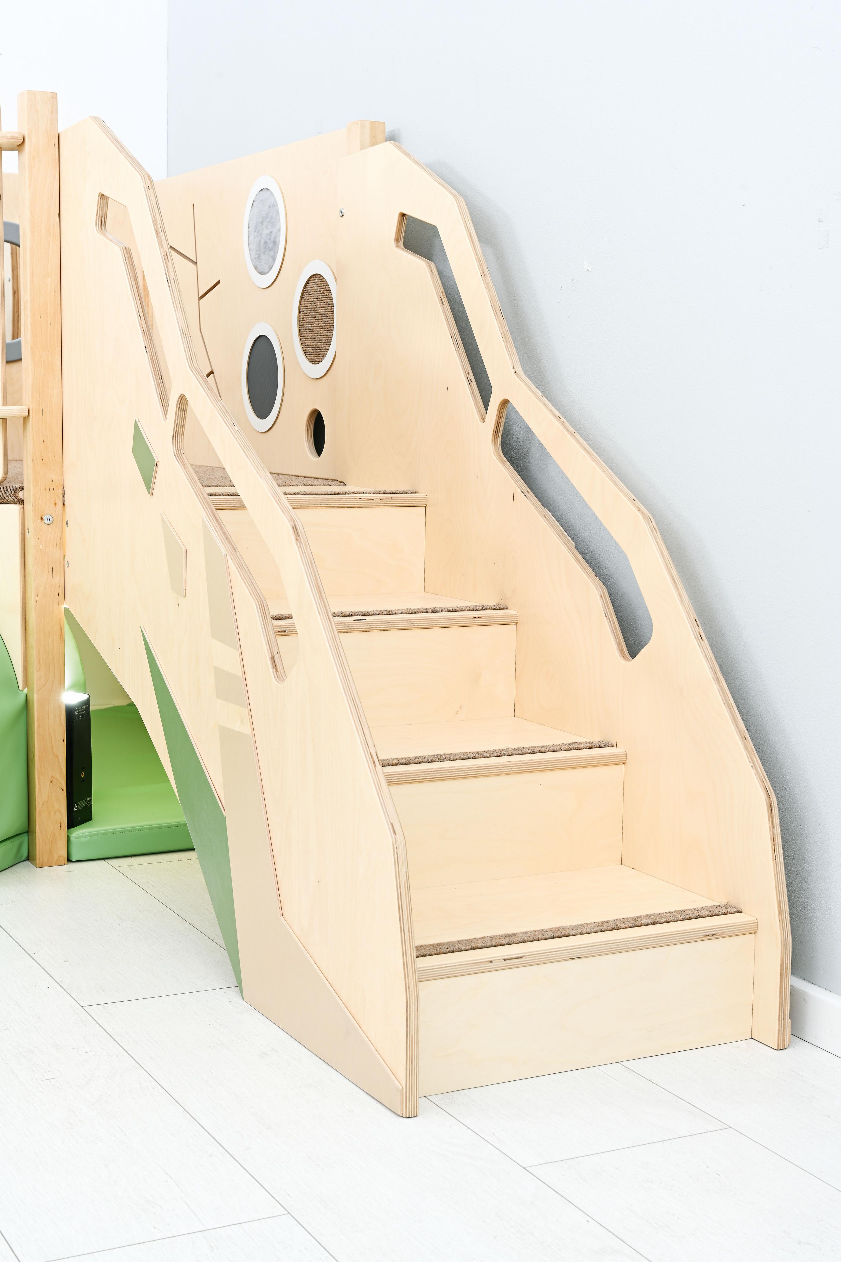 Sensorische Spielecke auf Holztreppe für Kitas und Krippen.
