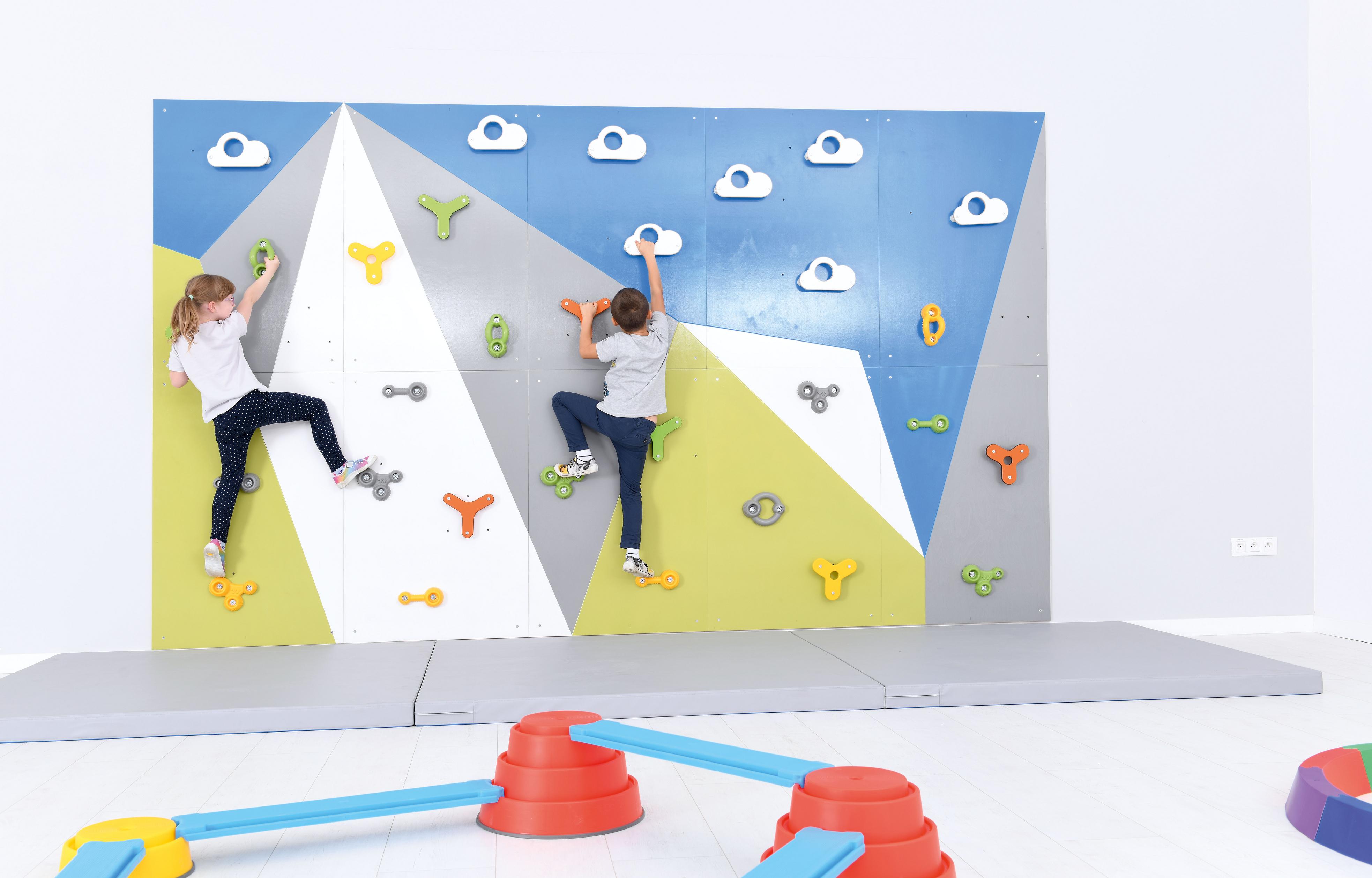 Bunte Kletterwand in der Turnhalle mit Kindern.