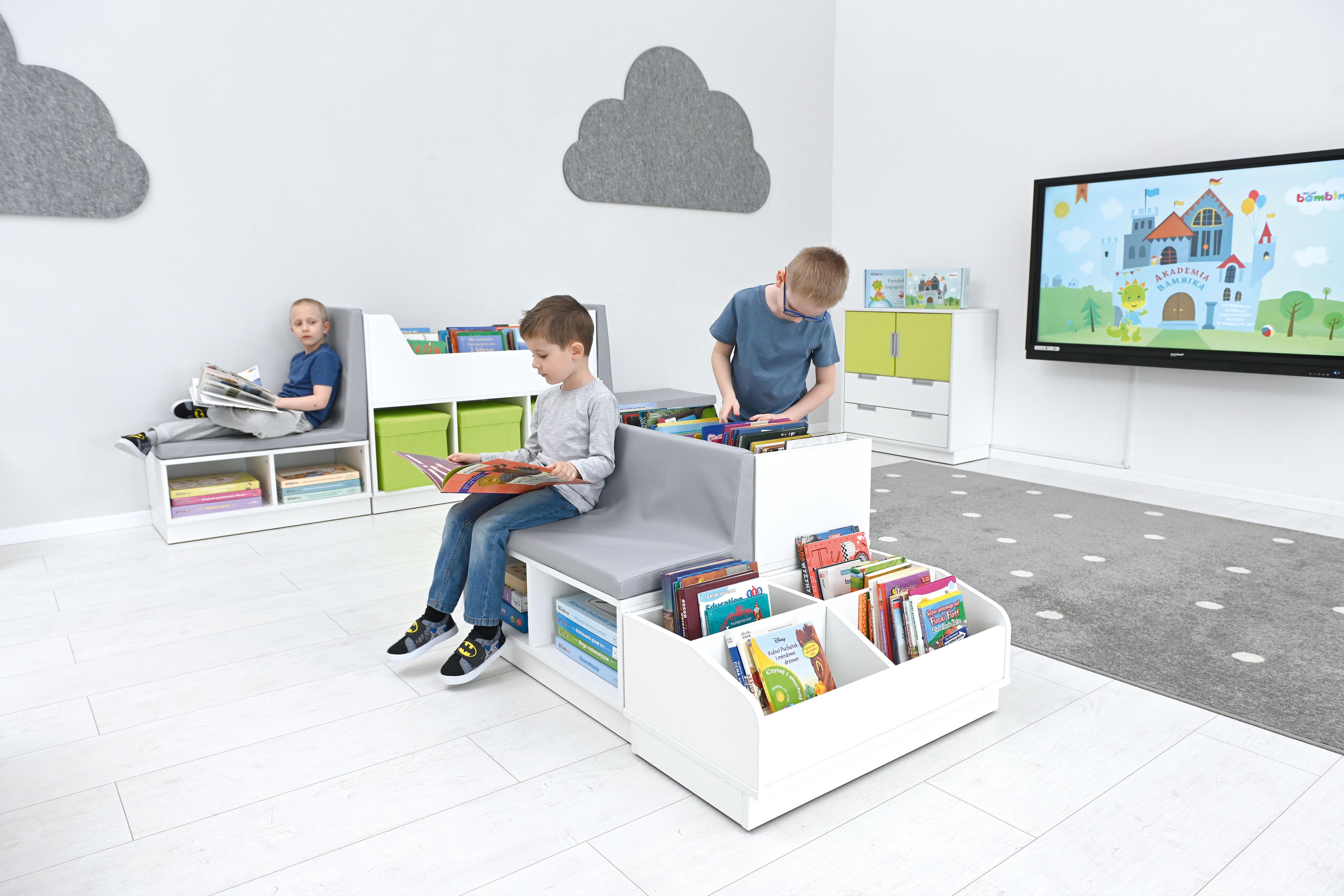 Kinder genießen Bücher auf der Quadro-Leseecke, helles Klassenzimmer. - Produkt wird im Kindergarten oder Schule genutzt.