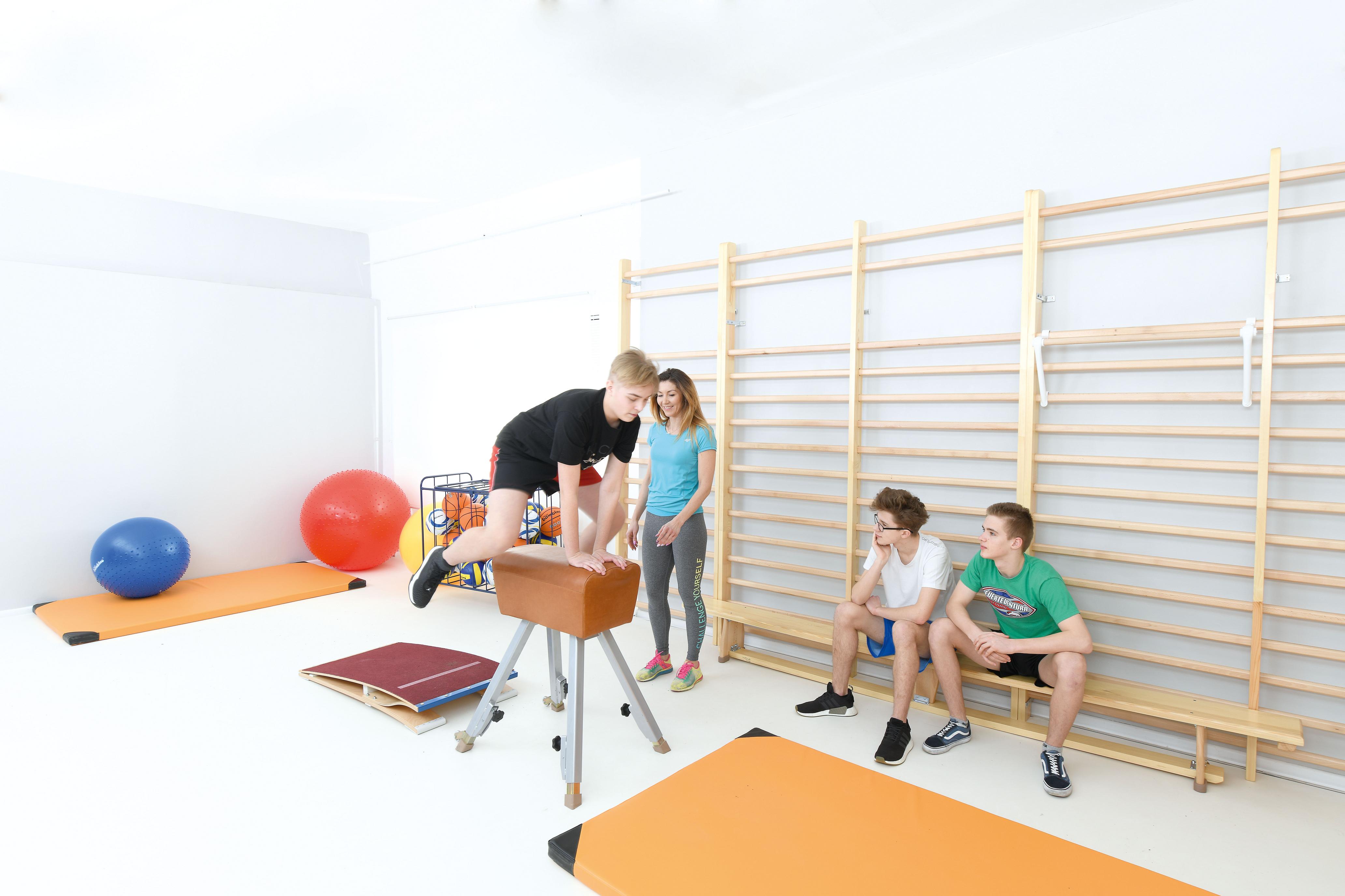 Kinder turnen und spielen auf Turnbank 3 m.