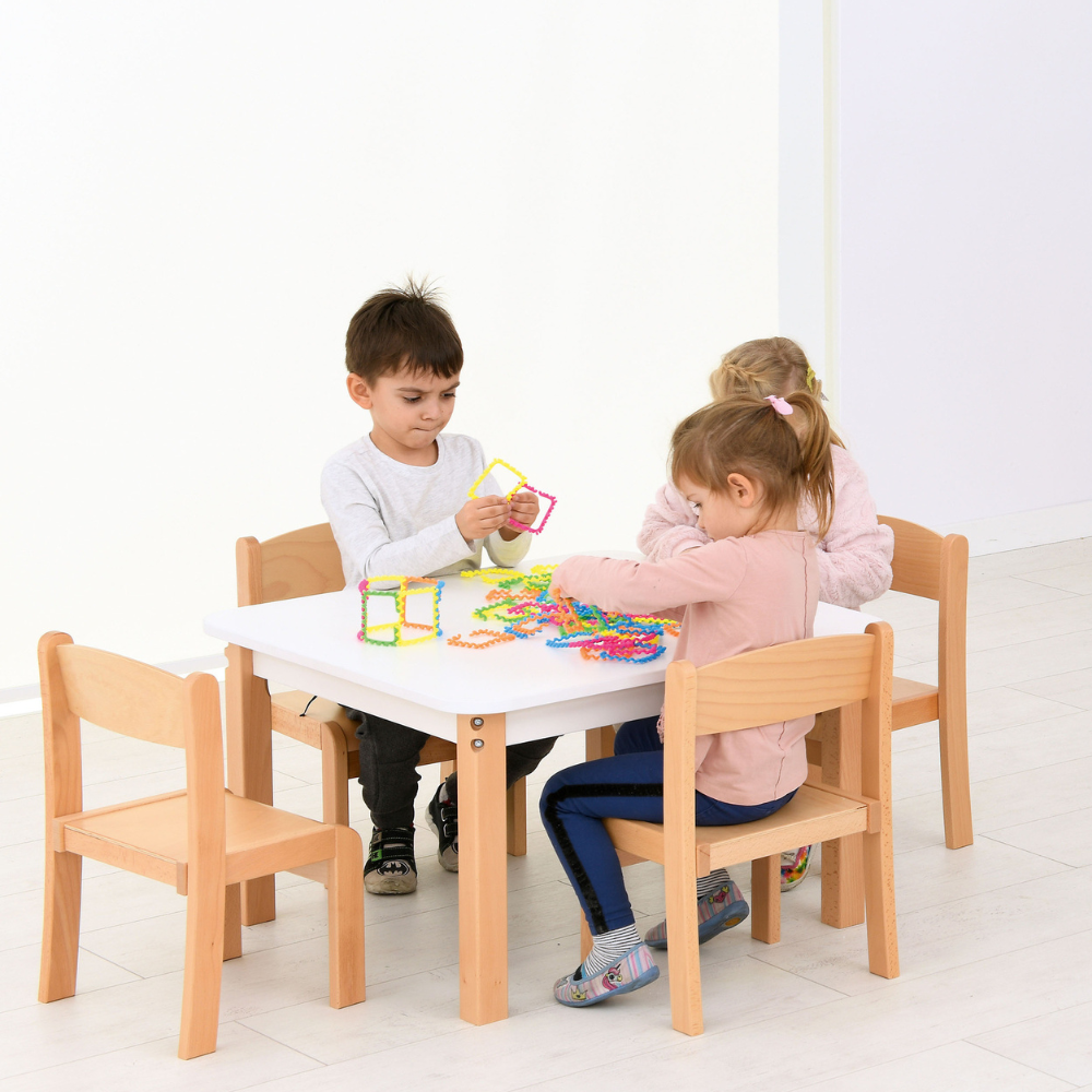 Kinder im Kindergarten sitzen auf Stühlen am Tisch.