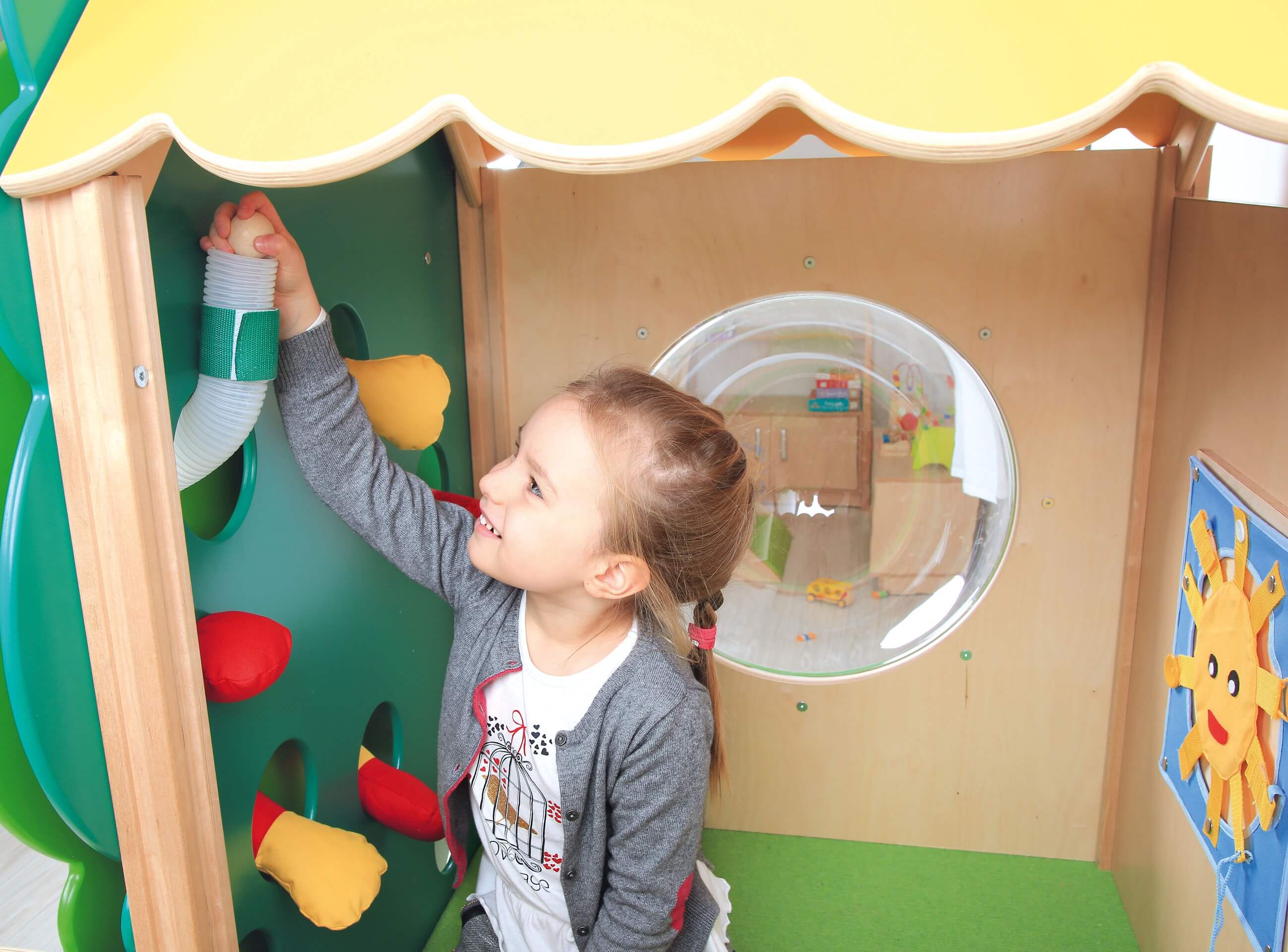 Kindergarten Spielpodest Baumhaus Kind spielt mit Kugelbahn 2