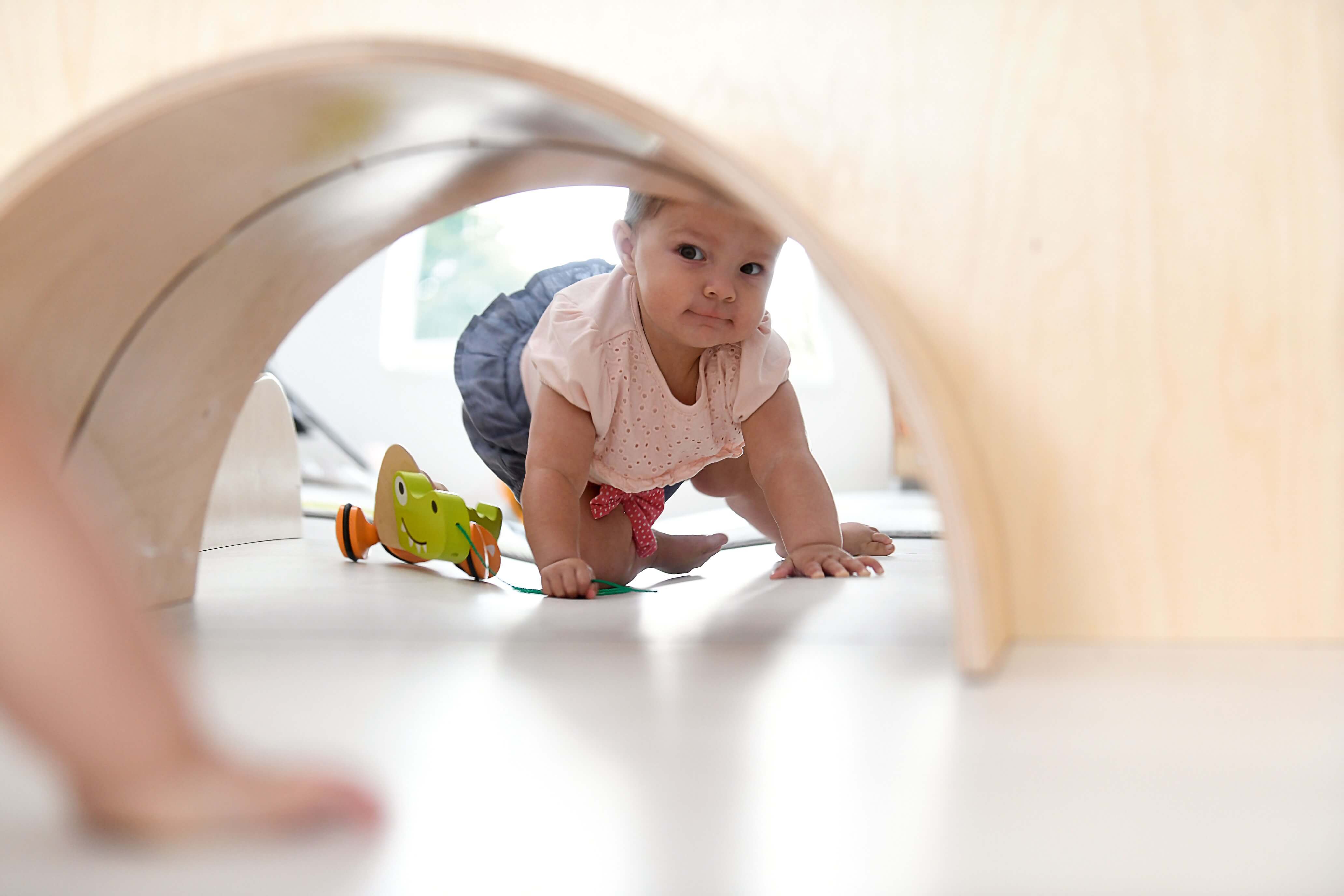 Spielpodest Iris für Kindergarten Detailansicht Krabbeltunnel mit Krippenkind