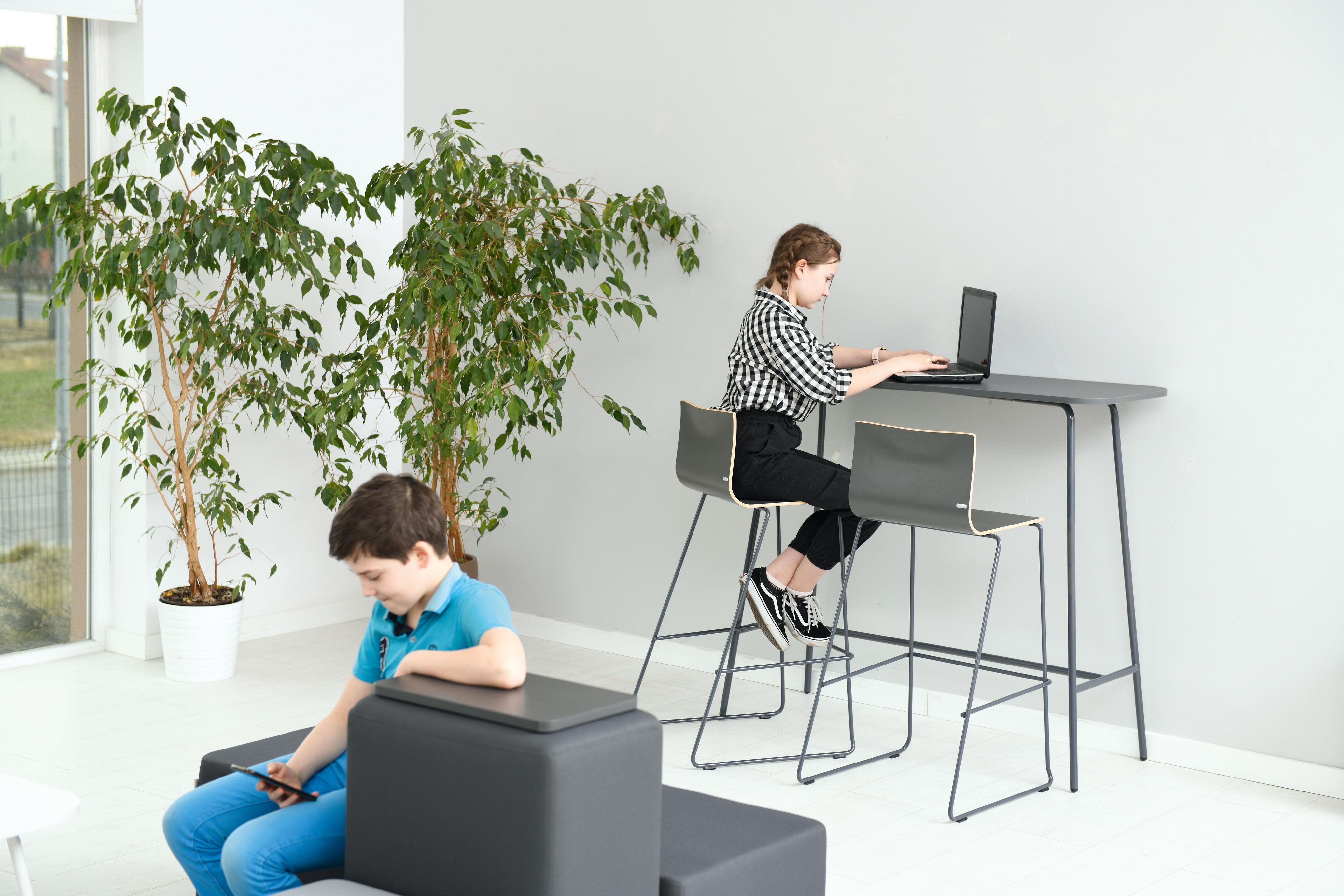 Kinder am Hochtisch im modernen Raum tätig.