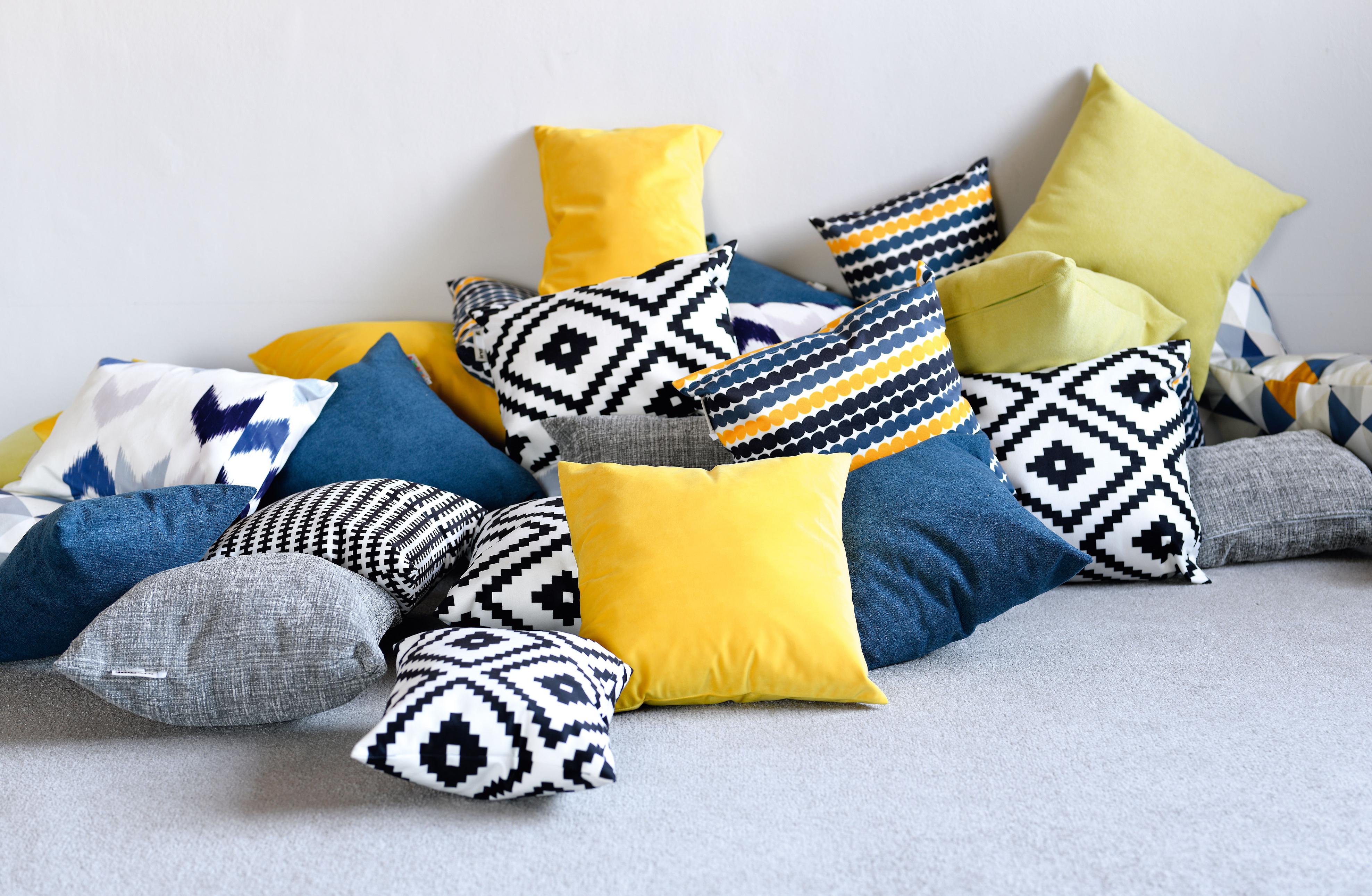 Bunte Kissen für Sitzlandschaft im Gruppenraum arrangiert.